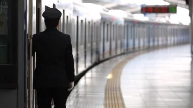 Metro Train Station Platform in Tokyo. Underground Metro Train During Rush Hour. People are Walking on Platform. Asian commuters traveling.