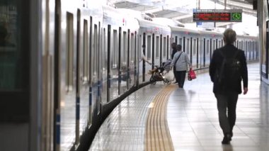 Metro Train Station Platform in Tokyo. Underground Metro Train During Rush Hour. People are Walking on Platform. Asian commuters traveling.