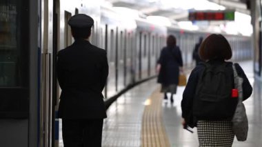 Metro Train Station Platform in Tokyo. Underground Metro Train During Rush Hour. People are Walking on Platform. Asian commuters traveling.