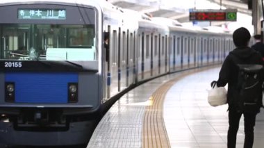 People are Walking on Platform in Metro Train Station Platform in Tokyo. Underground Metro Train During Rush Hour. The Train is Leaving. Asian commuters traveling.
