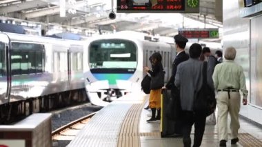 People are Walking on Platform in Metro Train Station Platform in Tokyo. Underground Metro Train During Rush Hour. Train is Approaching. Asian commuters traveling.