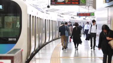 People are Walking on Platform in Metro Train Station Platform in Tokyo. Underground Metro Train During Rush Hour. Train is Ready To Depart. Asian commuters traveling.