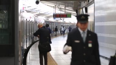 Metro Train Station Platform in Tokyo. Underground Metro Train During Rush Hour. People are Walking on Platform. Conductor Leaves the Train. Asian commuters traveling.