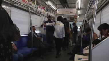 Tokyo Metro. Full Underground Metro Train During Rush Hour In Tokyo. People Are Sitting and Reading. Japanese people commuting on local train. Tourists on crowded train. Asian commuters traveling