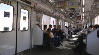 Tokyo Metro. Full Underground Metro Train During Rush Hour In Tokyo. People Are Sitting and Reading. Japanese people commuting on local train. Tourists on crowded train. Asian commuters traveling