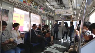 Tokyo Metro. Full Underground Metro Train During Rush Hour In Tokyo. People Are Sitting and Reading. Japanese people commuting on local train. Tourists on crowded train. Asian commuters traveling