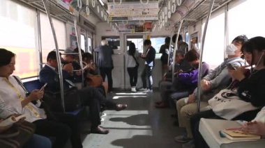 Tokyo Metro. Full Underground Metro Train During Rush Hour In Tokyo. People Are Sitting and Reading. Japanese people commuting on local train. Tourists on crowded train. Asian commuters traveling