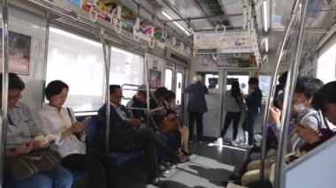 Tokyo Metro. Full Underground Metro Train During Rush Hour In Tokyo. People Are Sitting and Reading. Japanese people commuting on local train. Tourists on crowded train. Asian commuters traveling