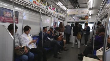 Tokyo Metro. Full Underground Metro Train During Rush Hour In Tokyo. People Are Sitting and Reading. Japanese people commuting on local train. Tourists on crowded train. Asian commuters traveling