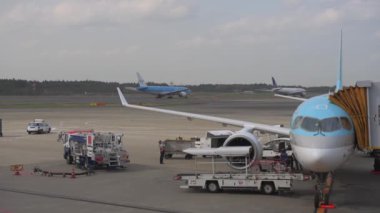 Korean Airlines airplane Airbus a220 arrived to Tokyo International Narita Airport. Ground Service is Working in Background. ANA Airlines, KLM Airplane are Taxing to Take Off. Bright Sunny Day