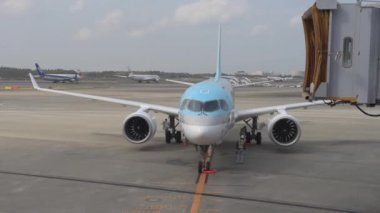 Korean Airlines airplane Airbus a220 arrived to Tokyo International Narita Airport. Ground Service is Working in Background. ANA Airlines, Tokyo Airplane are Taxing to Take Off. Bright Sunny Day