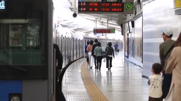 東京の地下鉄駅ホーム ラッシュ時の地下鉄列車 人々はプラットフォーム上を歩いています 車掌は列車を出る 指揮者は時間を確認してる アジアの通勤者 — ストック動画