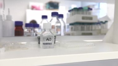 Water Bottle H2O in Laboratory. Sterile Conditions. Chemistry and Laboratory Glassware in Background