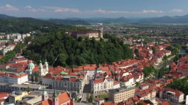 Ljubljana Kalesi ve Slovenya 'daki eski bir kasaba. Ljubljana en büyük şehirdir. Geniş Tivoli Parkı da dahil olmak üzere üniversite nüfusu ve yeşil alanları ile bilinir. Kavisli Ljubljanica Nehri. Drone, 4k