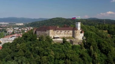 Ljubljana Kalesi ve Slovenya 'daki eski bir kasaba. Ljubljana en büyük şehirdir. Geniş Tivoli Parkı da dahil olmak üzere üniversite nüfusu ve yeşil alanları ile bilinir. Kavisli Ljubljanica Nehri. Drone, 4k