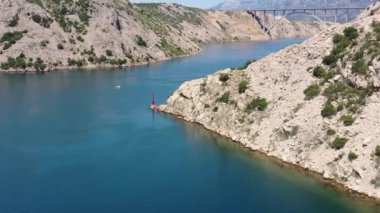 Hırvatistan 'daki Maslenica Köprüsü. Maslenica Köprüsü, Adriyatik Denizi 'nden Novsko Zdrilo Boğazı' na uzanan devlet karayolunu taşıyan bir güverte kemer köprüsü. Arka plandaki manzara çok güzel. 4k İHA