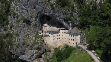 Slovenya, Avrupa 'daki Predjama Kalesi. Rönesans şatosu Slovenya 'nın güneyindeki bir mağara ağzında inşa edildi, tarihi Inner Carniola bölgesinde. Predjama köyünde yer almaktadır. Drone, 4k.