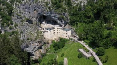 Slovenya, Avrupa 'daki Predjama Kalesi. Rönesans şatosu Slovenya 'nın güneyindeki bir mağara ağzında inşa edildi, tarihi Inner Carniola bölgesinde. Predjama köyünde yer almaktadır. Drone, 4k.