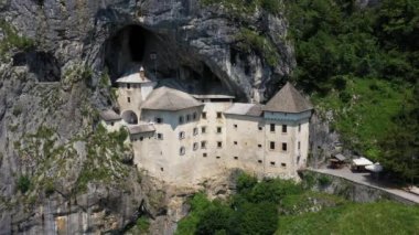 Slovenya, Avrupa 'daki Predjama Kalesi. Rönesans şatosu Slovenya 'nın güneyindeki bir mağara ağzında inşa edildi, tarihi Inner Carniola bölgesinde. Predjama köyünde yer almaktadır. Drone, 4k.