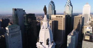 Philadelphia Belediye Binası Kulesi ve William Penn 'in bronz heykeli. Şehir manzarası ve Arkaplanda Güzel Günbatımı Işığı. Pennsylvania 4k