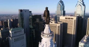 Philadelphia Belediye Binası Kulesi ve William Penn 'in bronz heykeli. Şehir manzarası ve Arkaplanda Güzel Günbatımı Işığı. Pennsylvania 4k