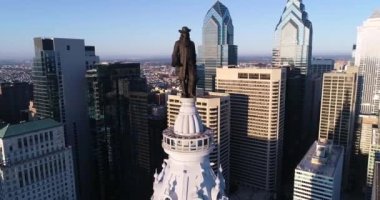 Philadelphia Belediye Binası Kulesi ve William Penn 'in bronz heykeli. Şehir manzarası ve Arkaplanda Güzel Günbatımı Işığı. Pennsylvania 4k