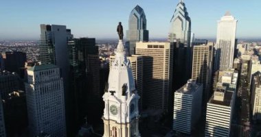 Philadelphia Belediye Binası Kulesi ve William Penn 'in bronz heykeli. Şehir manzarası ve Arkaplanda Güzel Günbatımı Işığı. Pennsylvania 4k