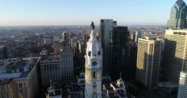 Philadelphia Belediye Binası Kulesi ve William Penn 'in bronz heykeli. Şehir manzarası ve Arkaplanda Güzel Günbatımı Işığı. Pennsylvania 4k