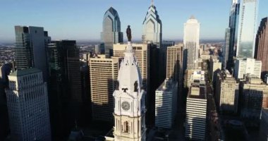 Philadelphia Belediye Binası Kulesi ve William Penn 'in bronz heykeli. Şehir manzarası ve Arkaplanda Güzel Günbatımı Işığı. Pennsylvania 4k