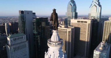Philadelphia Belediye Binası Kulesi ve William Penn 'in bronz heykeli. Şehir manzarası ve Arkaplanda Güzel Günbatımı Işığı. Pennsylvania 4k