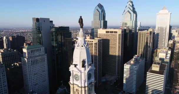 フィラデルフィア市役所の塔とウィリアム ペンのブロンズ像 背景には都市景観と美しい夕日の光 ペンシルベニア州4K — ストック動画