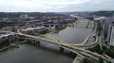 Pittsburgh Cityscape in cloudy day, Pennsylvania. Daytime with business district and river with three bridges in background. Point State Park and Fountain in Foreground