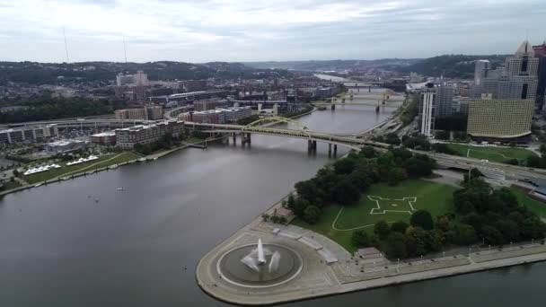 宾夕法尼亚州匹兹堡市多云的天气 白天与商业区和河流有三座桥梁为背景 位于前园的角国家公园及喷泉 — 图库视频影像