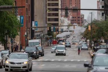 Baltimore, Maryland - October 03, 2019: Baltimore Downtown Street Water Steam. Traffic Vehicles. Steam and hot water. Maryland