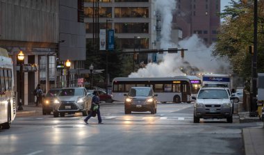 Baltimore, Maryland - October 03, 2019: Traffic in Baltimore, Maryland. USA. Hot Water Steam in Background. Downtown Street