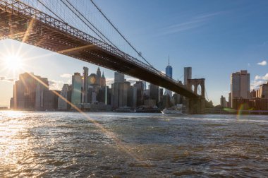 Brooklyn Bridge, East River and Lower Manhattan in Background. NYC Skyline. Bright Sunny Day and Sunlight. Dumbo. Sightseeing Place Among Locals and Tourists in NYC.