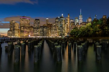 Beautiful Night Light and Lower Manhattan skyline with East River and New York City. Twilight with Reflections and Abandoned Pier at Sunset from Brooklyn Bridge Park