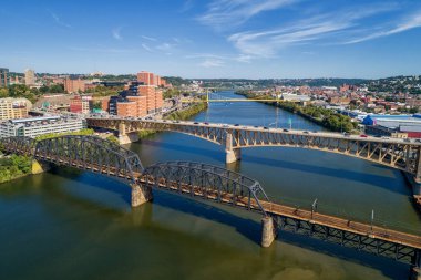 Pittsburgh Skyline with Downtown and Business District. Train Bridge and Liberty Bridge. Clear blue sky in the background.
