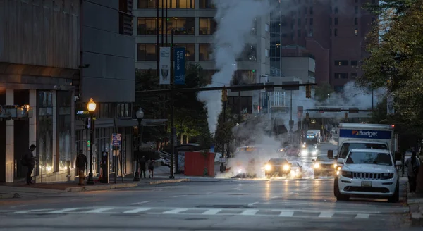 Baltimore, Maryland - October 03, 2019: Traffic in Baltimore, Maryland. USA. Hot Water Steam in Background. Downtown Street