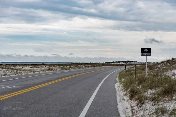 Bike Line Sign In Pensacola. Empty Road and Cloudy Sky