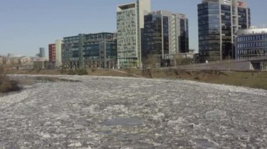 Ice Drift In Vilnius, Lithuania. River Neris. Ice floes float on the river in the spring. Ice drift movement. Winter landscape. Melting ice water, global warming and climate change concept
