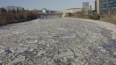 Ice Drift In Vilnius, Lithuania. River Neris. Ice floes float on the river in the spring. Ice drift movement. Winter landscape. Melting ice water, global warming and climate change concept