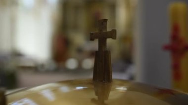 Small Cross in Catholic Church. Blurry Background. Church Interior. Symbol of Christian Religious. Closeup Video.