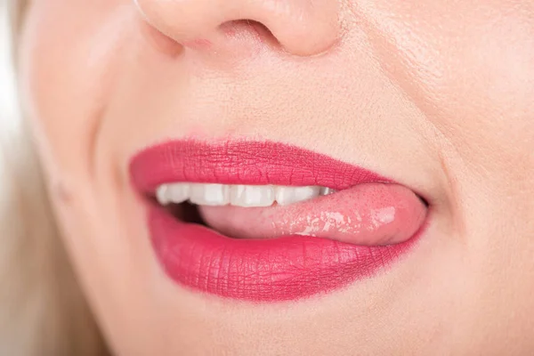 口を開けて舌を出す女の顔 使用中の明るい赤の口紅と白の歯 — ストック写真