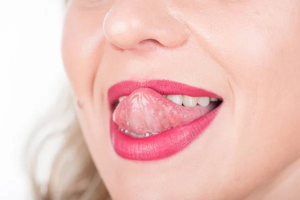 Woman Face with Open Mouth And Tongue Out. Bright Red Lipstick in Use and White Teeth. Try To Touch Nose.