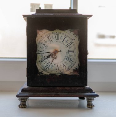 Old Wooden Clock is in Front of the Window