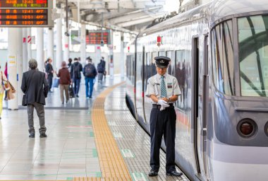 TOKYO, JAPONYA - 30 Ekim 2019: Shinjuku, Tokyo, Japonya 'daki Seibu Shinjuku Tren İstasyonu. Tren şoförü saate bakıyor.