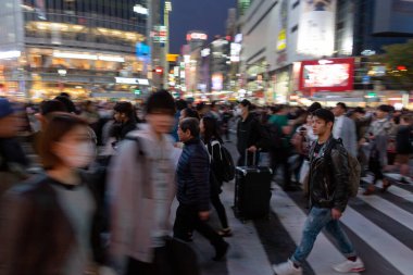 TOKYO, JAPAN - OCTOBER 30, 2019: Shibuya Crossing in Tokyo, Japan. The most famous intersection in the world. Blurry beacause of the panning.