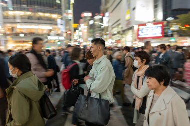 TOKYO, JAPAN - OCTOBER 30, 2019: Shibuya Crossing in Tokyo, Japan. The most famous intersection in the world. Blurry beacause of the panning.