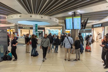 ROME, ITALY - OCTOBER 23, 2019: Rome international Leonardo da Vinci Fiumicino Airport interior with people. Departure area with Duty Free shops and Departure Screens.